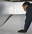 A contractor installing TerraBlock™ floor insulation in a Mount Pleasant crawl space