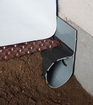 Closeup of a crawl space drainage system installed in Gaylord