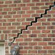 stair step cracking reaching from a window along the foundation wall in Kalamazoo