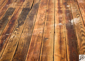 A [city] wood floor displaying water damage.